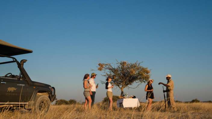 Eine Gruppe von Menschen steht in einem Feld neben einem jeep