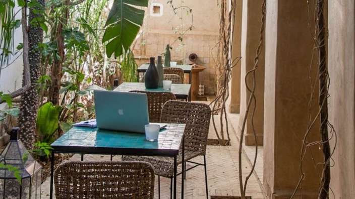 Ein Laptop sitzt auf einem Tisch in einem Garten