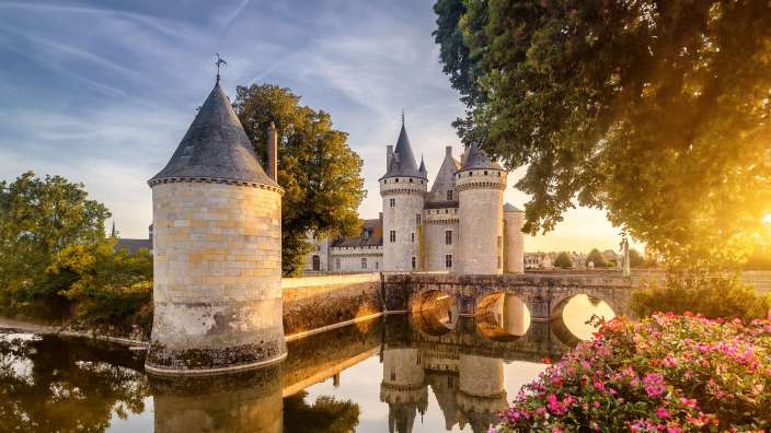 Ein altes Schloss mit einer Brücke über einen Fluss