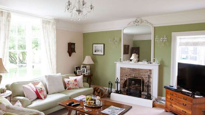 Ein Wohnzimmer mit grünen Wänden und einem Kamin