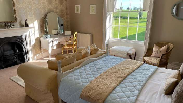 Ein Schlafzimmer mit einem Bett, einem Stuhl und einem Spiegel