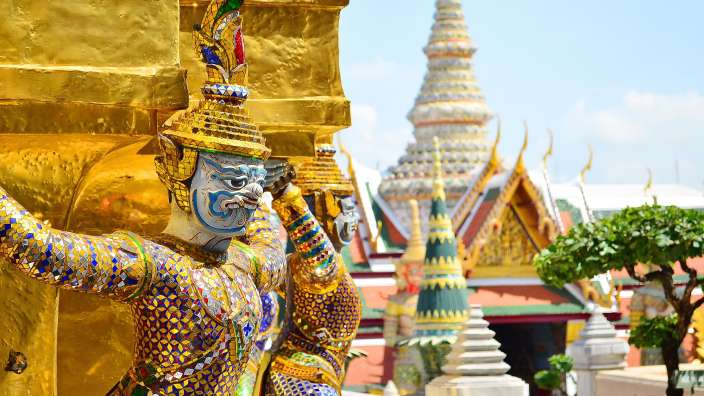 Eine Statue steht vor einem goldenen Gebäude