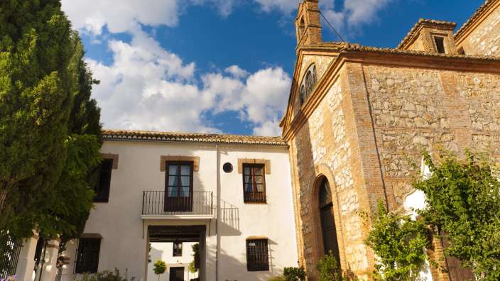 Ein weißes Gebäude mit einem braunen Backsteingebäude dahinter