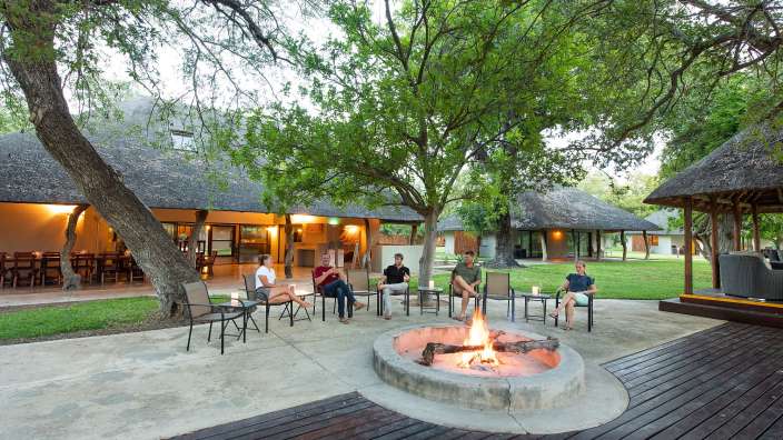 Eine Gruppe von Menschen sitzt um einen Feuerplatz