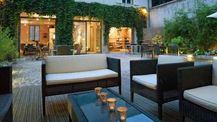 Eine Terrasse mit Möbeln und Kerzen auf einem Tisch