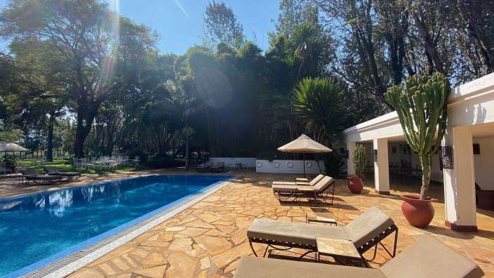 Ein Swimmingpool mit Liegestühlen und Sonnenschirmen umgeben