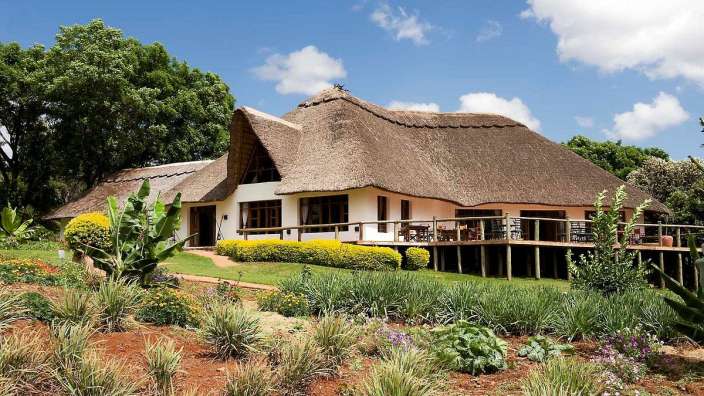 Ein Haus mit Strohdach und einer Holzterrasse