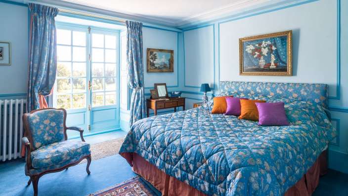 Ein blaues Schlafzimmer mit einem Bett und einem Stuhl