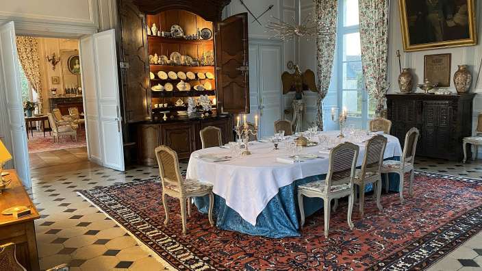 Ein Esszimmer mit einem Tisch und Stühlen und einem Teppich