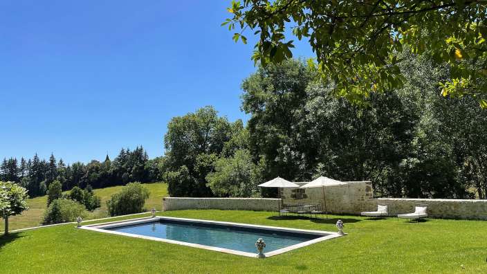 Ein großer Swimmingpool in einem üppigen grünen Garten