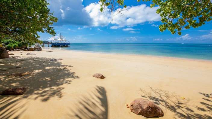 Ein Strand mit einem kleinen Boot im Hintergrund