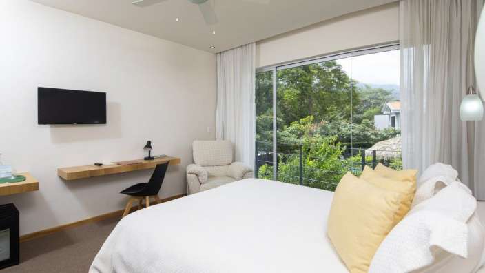 Ein Schlafzimmer mit einem Bett, einem Stuhl und einem Fernseher