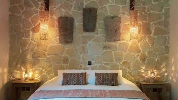 Ein Schlafzimmer mit einem Bett und einer Steinmauer