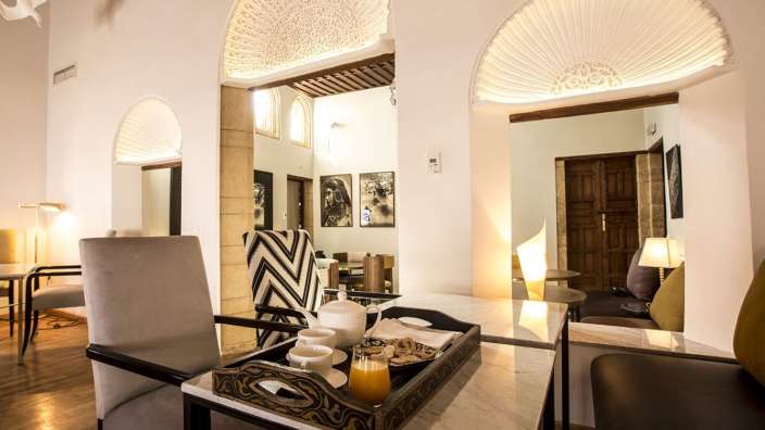 Ein Tisch mit einem Tablett mit Tassen und einem Glas Orangensaft darauf