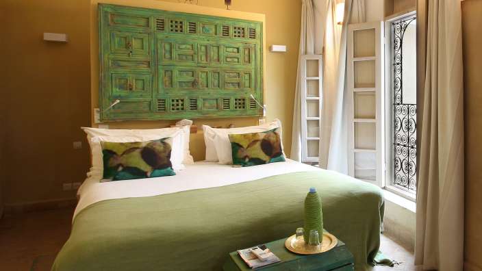 Ein Schlafzimmer mit einem Bett und einer grünen Kommode