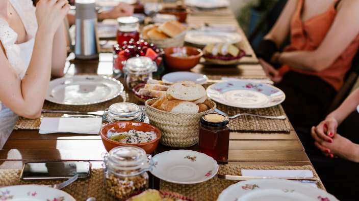 Eine Gruppe von Frauen sitzt an einem Tisch mit Tellern und Gläsern