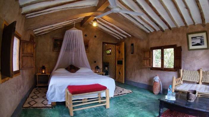 Ein Zimmer mit einem Bett und einem Ventilator an der Decke