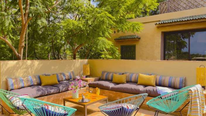 Eine Terrasse mit bunten Stühlen und einem Tisch