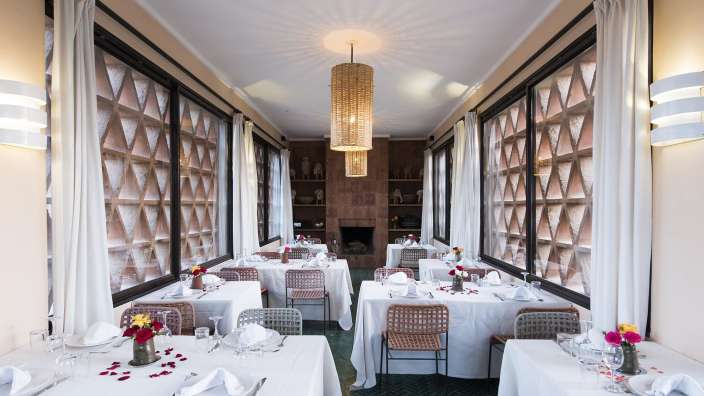 Ein langes Esszimmer mit weißen Tischen und Stühlen