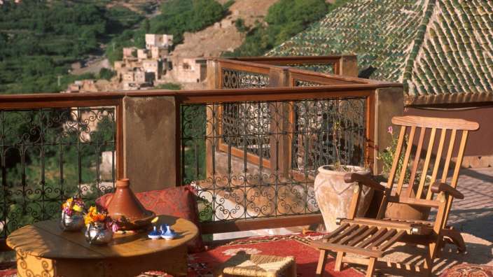 Eine Terrasse mit einem Tisch und einem Schaukelstuhl