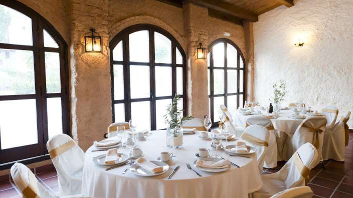 Eine Reihe von Tischen und Stühlen in einem Raum mit vielen Fenstern