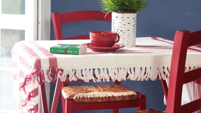 Ein rot-weiß gestreifter Tisch mit einer Tasse und einem Buch