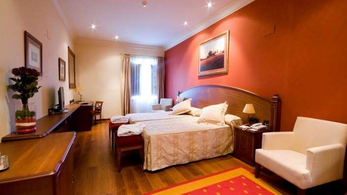 Ein Hotelzimmer mit zwei Betten und einem Stuhl
