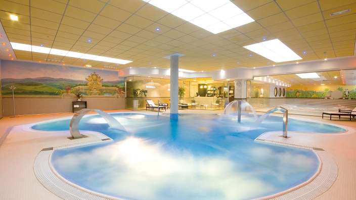 Ein riesiges Schwimmbad mit einer Wandmalerei an der Decke