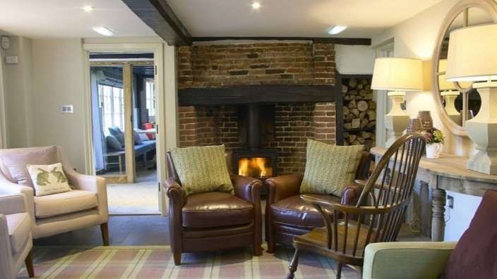 Ein Wohnzimmer mit Stühlen und einem Kamin