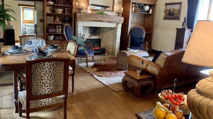 Ein Wohnzimmer mit einem Tisch und Stühlen und einem Kamin