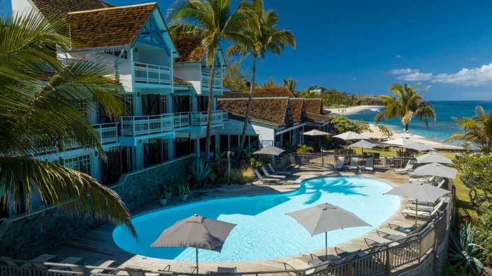 Ein großer Swimmingpool umgeben von Sonnenschirmen und Stühlen