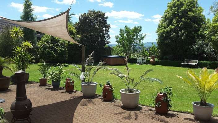 Ein Garten mit vielen Pflanzen und einem Whirlpool im Hintergrund
