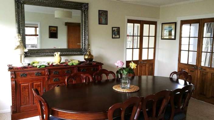 Ein Esszimmer mit einem Tisch und Stühlen und einem großen Spiegel