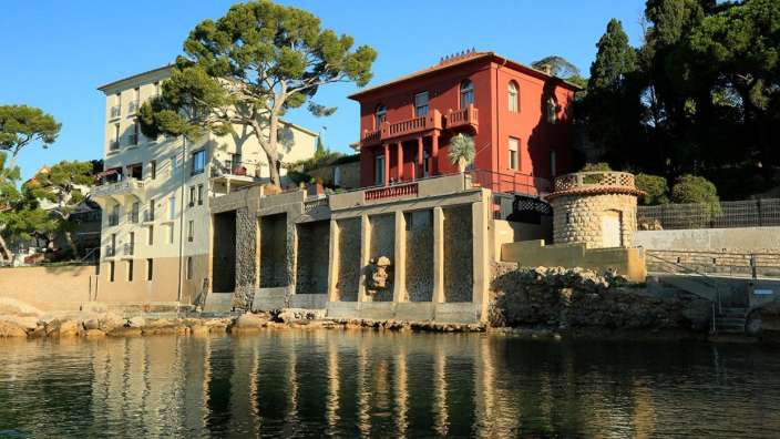 Ein großes rotes Haus steht neben einem kleinen weißen Haus