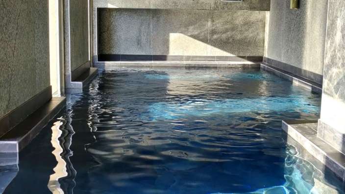 Ein großer Pool mit blauem Wasser in einem Gebäude