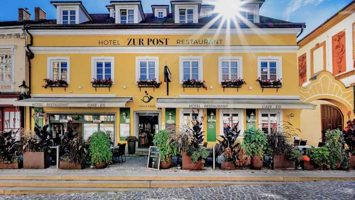 Ein gelbes Gebäude mit der Aufschrift Hotel zur Post Restaurant darauf