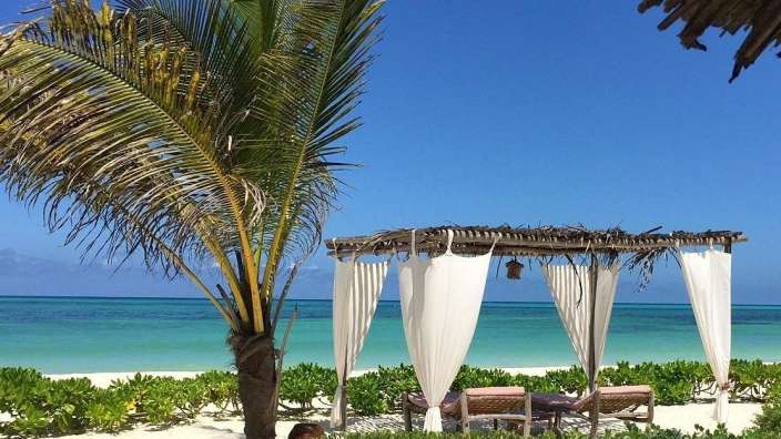 Ein weißes Zelt am Strand mit Blick auf das Meer