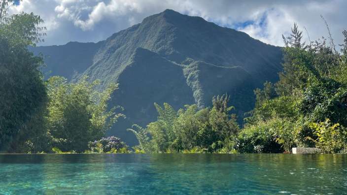 Ein Pool mit einem Berg im Hintergrund
