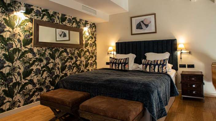 Ein Schlafzimmer mit einem Bett und zwei Hockern