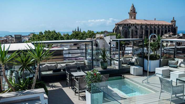 Eine Terrasse mit einem Pool und einer Kirche im Hintergrund