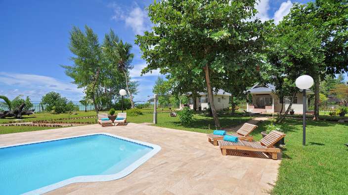 Liegestühle stehen neben einem Swimmingpool in einem Garten