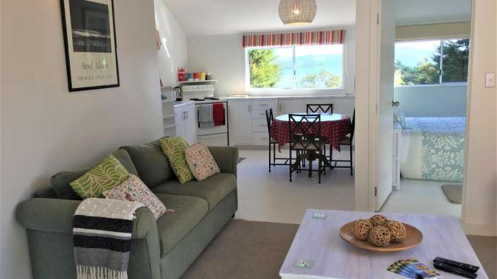 Ein Wohnzimmer mit einer grünen Couch und einem weißen Tisch