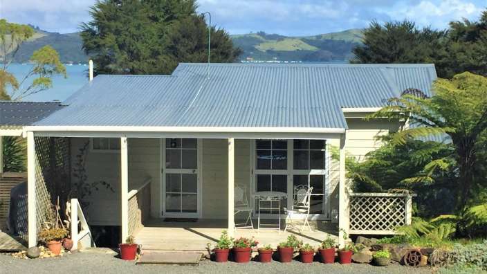 Ein kleines Haus mit einem Metalldach und einer Veranda