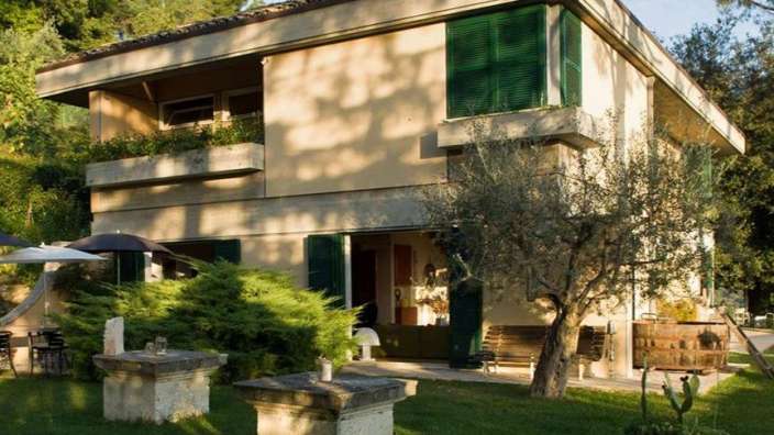 Ein großes Haus mit grünen Fensterläden und Balkonen