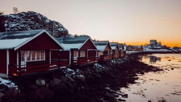 Eine Reihe von roten Hütten neben einem Fluss