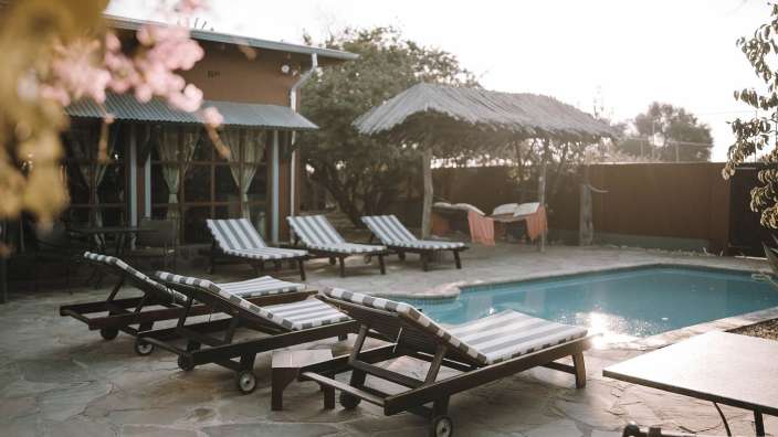 Liegestühle in der Nähe eines Swimmingpools neben einem Haus
