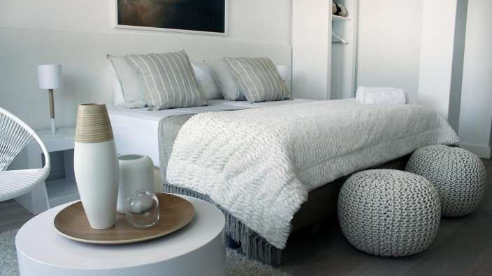 Ein Schlafzimmer mit einem Bett und einem Tisch mit Vasen darauf