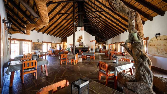 Ein Esszimmer mit Tisch und Stühlen und Strohdach