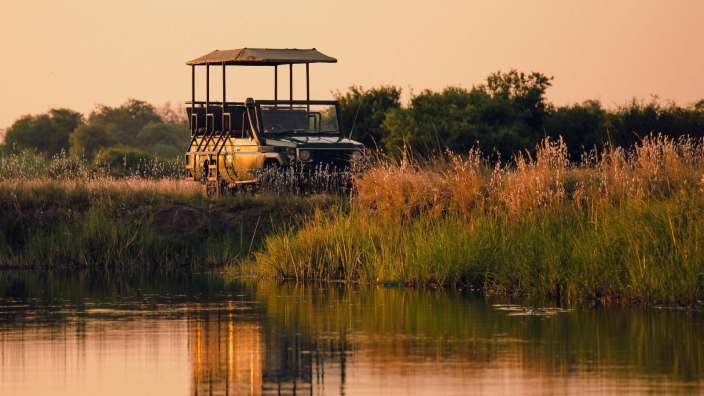 Ein gelb-schwarzer Jeep fährt über einen Fluss
