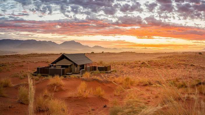 Ein kleines Haus in der Wüste bei Sonnenuntergang